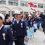５年生が作った花道をくぐる卒業生＝上荘小学校