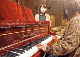 修理を終え戻ってきたグランドピアノの音色を確かめる加古川市職員＝松風ギャラリー