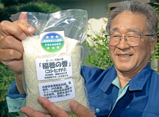 温室ガス削減と生物多様性保全でダブル三つ星を獲得し、専用ラベルが貼られた小山和彦さんのコシヒカリ＝稲美町加古