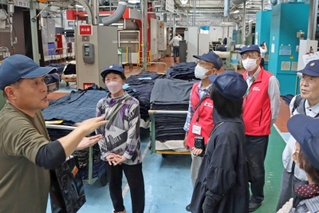 社員から説明を受けながら工場見学する参加者＝加古川市米田町、ニッケ印南工場