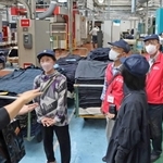 社員から説明を受けながら工場見学する参加者＝加古川市米田町、ニッケ印南工場