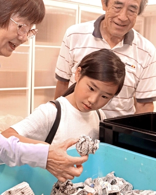 飼育について助言を受け、スズムシの幼虫を観察する参加者＝加古川市加古川町篠原町