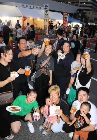 「乾杯」の音頭を弾ませ、笑顔で飲み交わす来場者＝播磨町役場前