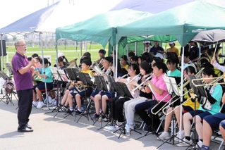 町内のイベントで演奏する「稲美町吹奏楽団コスモシンフォニックウィンズ」と中学生の合同バンド＝稲美町岡