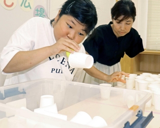 風船を膨らませて紙コップを持ち上げ、移動させる＝いなみっこ広場