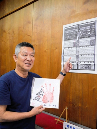 妙義龍の中学時代の担任、六角光昭さん。「こんな先輩がおると知らせたくて」と荒井中の校長室に色紙や番付表を飾ってもらっている＝高砂市荒井町千鳥３