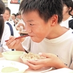 播磨町の食材を使った「たこめし」を頰張る児童＝播磨南小学校