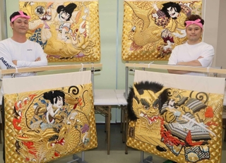 高欄掛けの新調を喜ぶ秋祭り保存会のメンバー。蘆屋道満（右上）と安倍晴明（左上）が対決する様子などが描かれている＝加古川市西神吉町岸