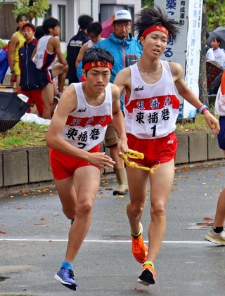 男子・東播磨の１区前田浬選手（右）がたすきを２区黒嶋桂選手につなぐ＝西脇市西脇