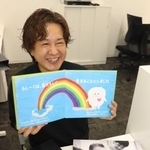 これまで撮影した家族写真や、自分らしく生きるために描いた絵本を手にする坂元拓海さん＝高砂市内