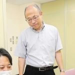 会議資料に目を通す日の出医療福祉グループの山本勝也業務執行理事（右）＝加古川市平岡町新在家