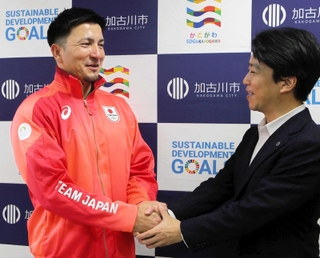 岡田康裕市長（右）と握手するディーン元気選手＝加古川市役所