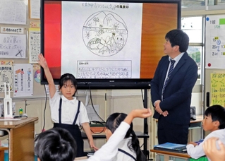 高御位山やかつめしのイラストが散りばめられた風景印の案を加古川東神吉郵便局の井上大輔局長（右）に提案する児童たち＝西神吉小学校
