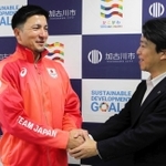岡田康裕市長（右）と握手するディーン元気選手＝加古川市役所
