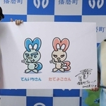 おなじみのエナメルスーツで新ＰＲキャラクターの「てんいちさん」「たてよこさん」をアピールするレイザーラモンＨＧさん（左）＝播磨町役場（同町提供）