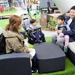 社会実験で置かれたガーデンソファーでくつろぐ家族連れら＝加古川市加古川町篠原町