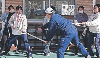 ダミーのナイフを振りかざす不審者役（手前）に刺股を使い対応する保育教諭ら＝播磨町北本荘４、播磨西こども園