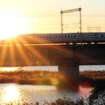 夕焼けを背景に加古川を滑るように通過する新幹線＝加古川市加古川町稲屋