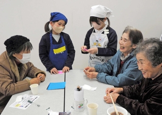 認知症カフェ「あさがおカフェ」で高齢者と笑顔で会話を楽しむ志方小児童（中央の２人）＝志方公民館