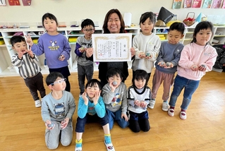 優秀園の表彰状を手にする森川綾子園長（中央）と尾上幼稚園の園児ら＝加古川市尾上町長田