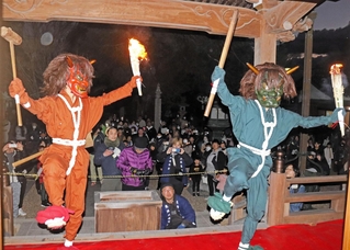 炎を上げるたいまつを持って舞う鬼＝高薗寺