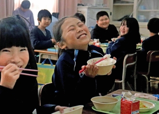 新米の「万葉の香」を頰張る児童たち＝天満東小学校