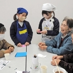 認知症カフェ「あさがおカフェ」で高齢者と笑顔で会話を楽しむ志方小児童（中央の２人）＝志方公民館