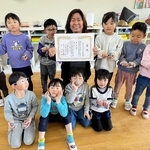 優秀園の表彰状を手にする森川綾子園長（中央）と尾上幼稚園の園児ら＝加古川市尾上町長田