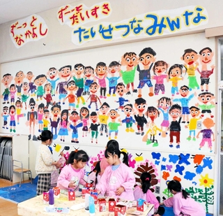 ２階ホールの壁に自画像やお気に入りの風景を描く阿弥陀こども園の園児＝高砂市阿弥陀町阿弥陀