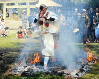 護摩をたいた後の木を並べてはだしでわたる「火渡りの儀」。この後、一般参拝者が続いた＝鶴林寺