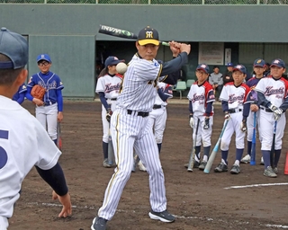 トスバッティングで実演する桧山進次郎さん＝加古川市加古川町大野