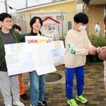 宮城県石巻市で咲いた「ど根性ひまわり」の種を配る米田小６年生＝高砂市米田町米田