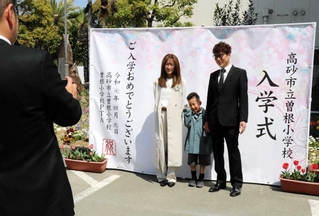 初お目見えしたフォトスポットで記念撮影する親子＝曽根小学校