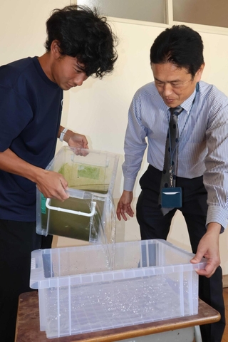 兵大メダカの水槽を移し替える西浦結生さん（左）と荒井小学校の矢野仁之校長＝高砂市荒井町東本町