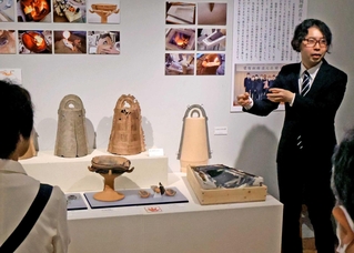 内覧会で銅鐸の種類や特徴などを説明する県立考古博物館の藤原怜史さん＝播磨町大中１