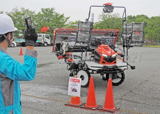 人工衛星電波で位置情報を補正し、自動で動く田植え機のデモンストレーション＝稲美町北山