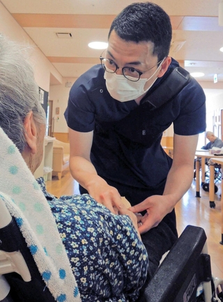 問診や触診で特別養護老人ホームの入所者の状態をチェックする診療看護師の渡部秀悟さん＝加古川市平荘町山角