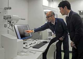 電子顕微鏡でとらえたウイルスの画像を確認する斎藤元彦知事（右）＝加古川市神野町神野