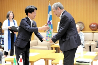 マリンガ市のバーロス・シウヴィオ市長（右）から記念品を受け取る岡田康裕市長＝加古川市役所