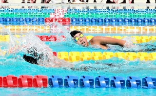 水しぶきを上げて競う選手＝明石海浜プール
