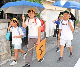 日傘を差しながら帰る児童＝稲美町野谷