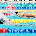 水しぶきを上げて競う選手＝明石海浜プール