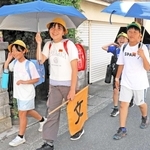 日傘を差しながら帰る児童＝稲美町野谷