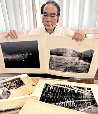 射撃訓練の様子などを収めた写真を手にする菊本睦人さん＝加古川市役所