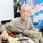 相棒のアコーディオンを見やる田中唯介さん。高齢で足がふらつき、演奏は難しくなったという＝高砂市高砂町栄町