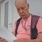 父の昇さんが戦地から家族へ宛てた手紙を読む喜多村甫さん＝稲美町役場