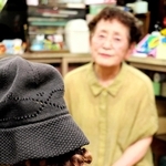 作った前髪ヘアバンドを顔に見立てた段ボールに付けてみる。「帽子をかぶせると自然でしょ」と田中さん＝加古川市加古川町寺家町