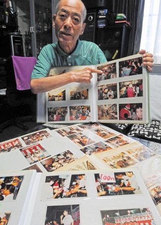 東加古川総合市場協同組合で理事長を務めた松本昌幸さん。アルバムを手に往時のにぎわいを懐かしむ＝加古川市加古川町備後