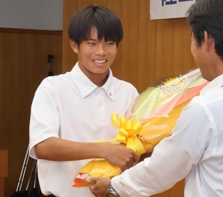 中山哲郎町長（右）から花束を受け取る中川悠聖さん＝稲美町役場