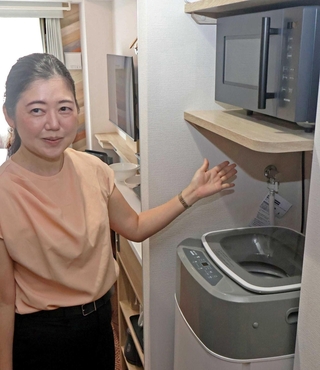 部屋を案内するサンフロンティア不動産の渡辺享子さん。長期利用も想定、客室には洗濯機なども備えられる＝加古川市別府町緑町１